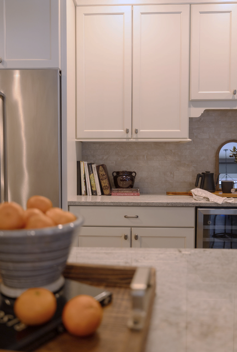 Transitional Ivory kitchen with light counters and shaker style cabinetry with beaded inlay. Featherstone Interior Design. Pulled together homes without the luxury price tag.