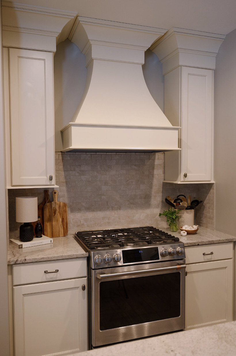 Ivory kitchen with GE Cafe' Gas range. Marble backsplash. Featherstone Interior Design.
