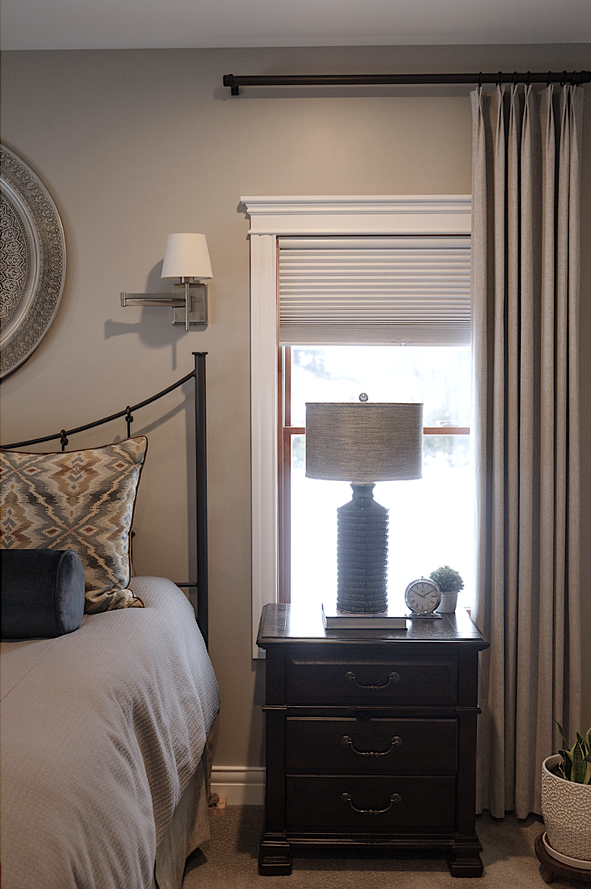 Primary bedroom. Custom bedding. Custom drapery. Sconce over bed. Iron bed frame.Transitional gray bedroom. Featherstone Interior Design.