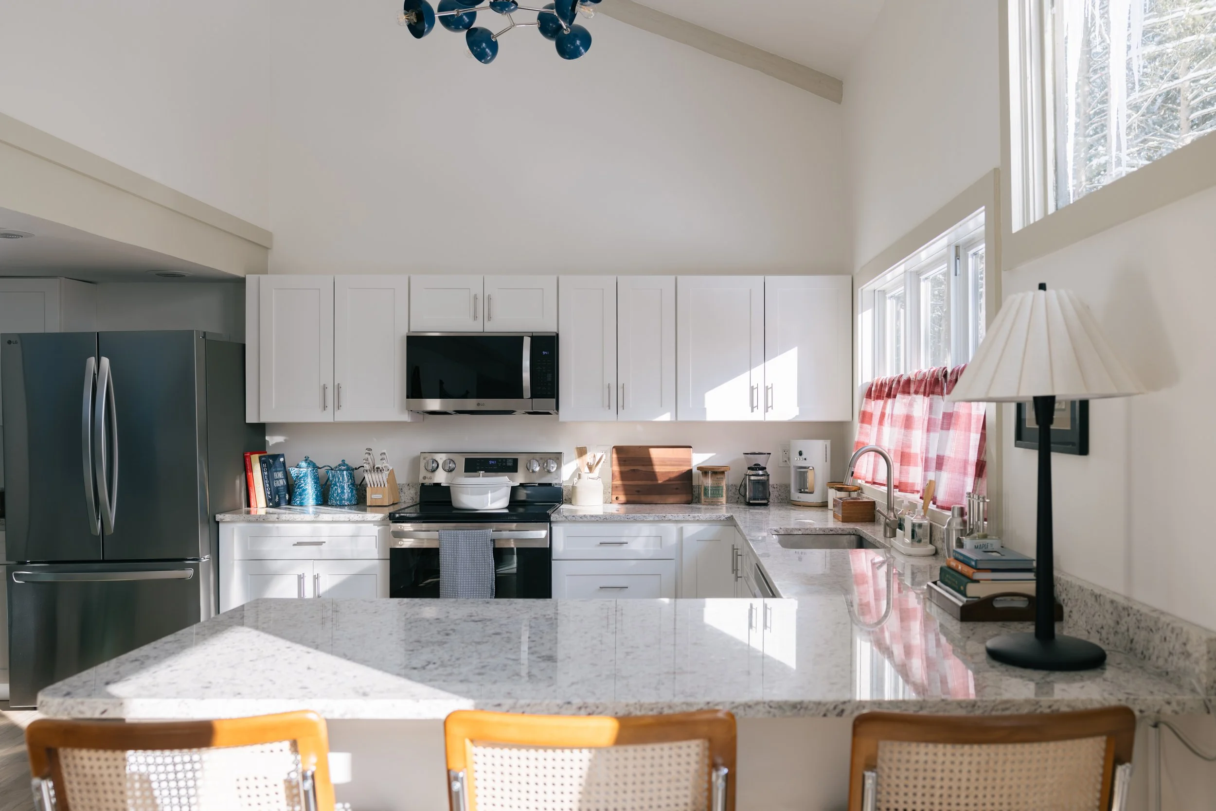 Bright kitchen at Pine & Plaid in Quechee, Vermont with white cabinetry and stainless steel appliances.