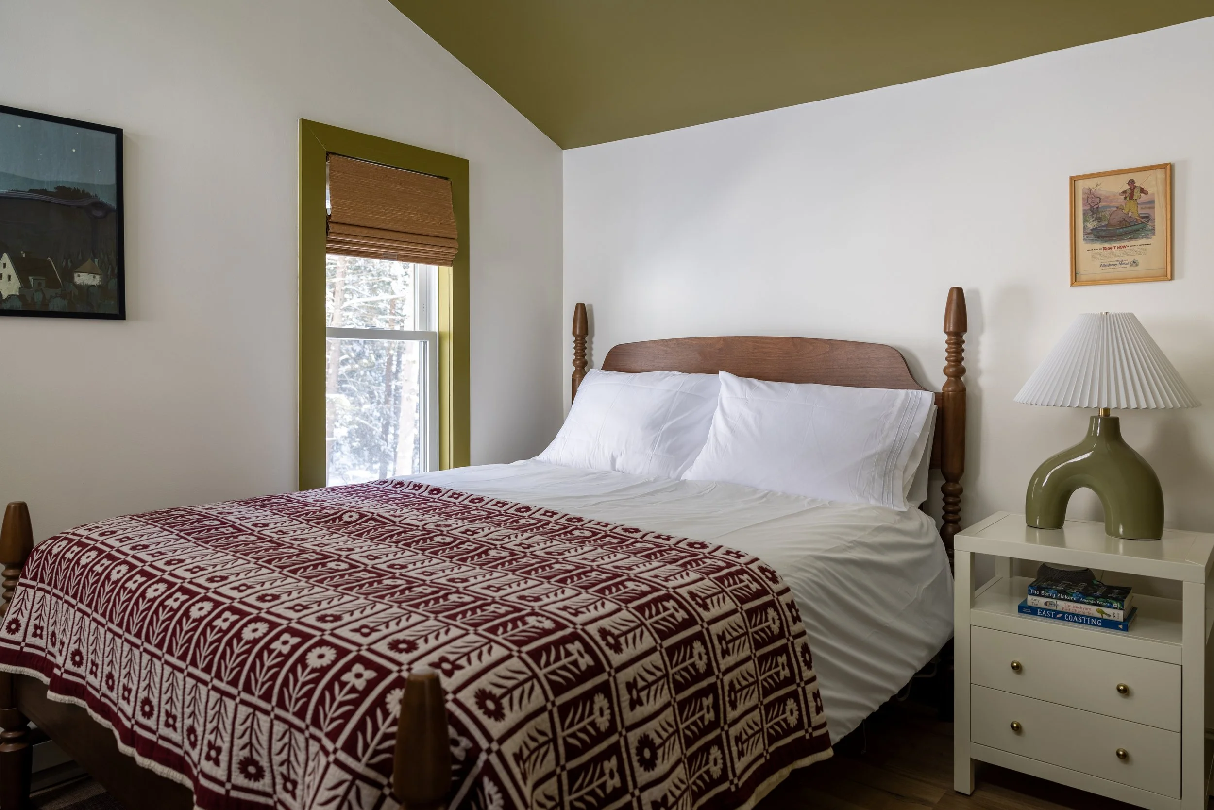Bedroom at Pine & Plaid in Quechee, Vermont with wood bed frame and red patterned throw blanket.