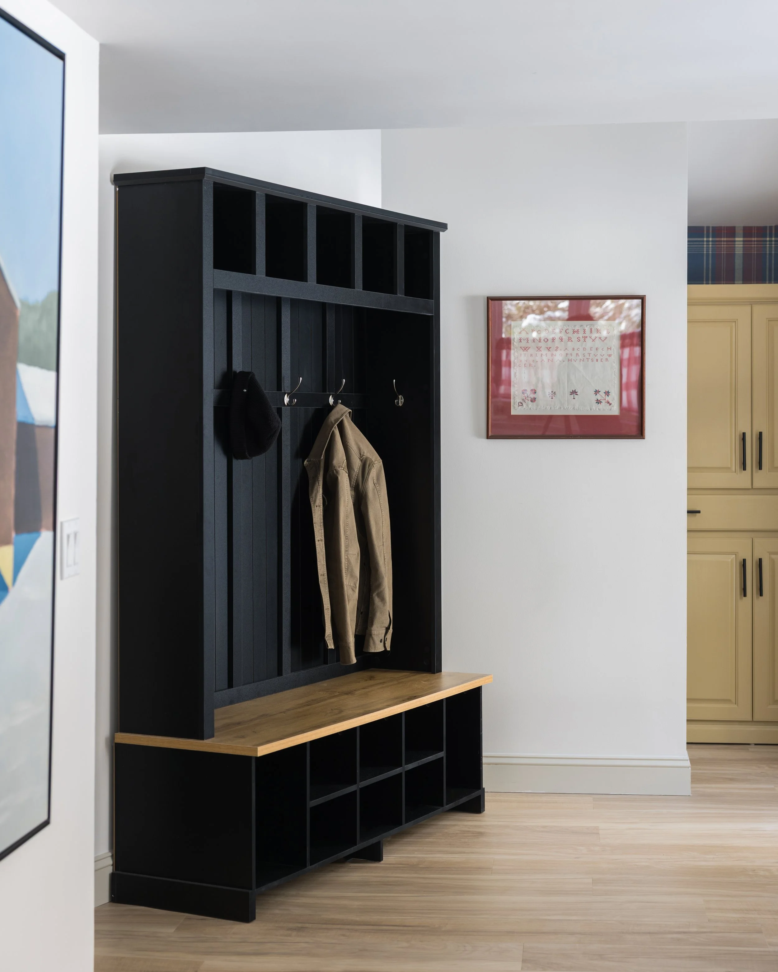 Entryway at Pine & Plaid cabin rental in Quechee, Vermont featuring coat rack and storage bench.