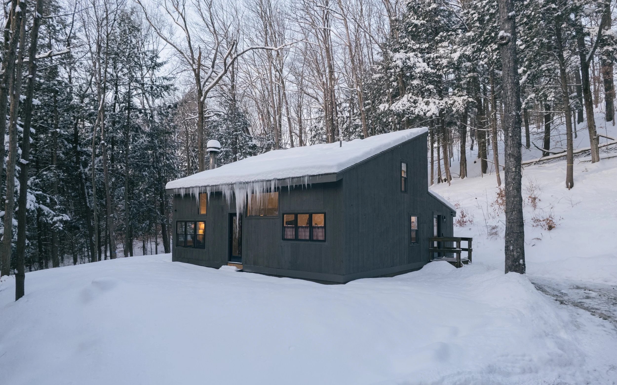 Exterior view of Pine & Plaid cabin in Quechee, Vermont surrounded by snow in winter. Modern short-term vacation rental located near Woodstock, Vermont. 