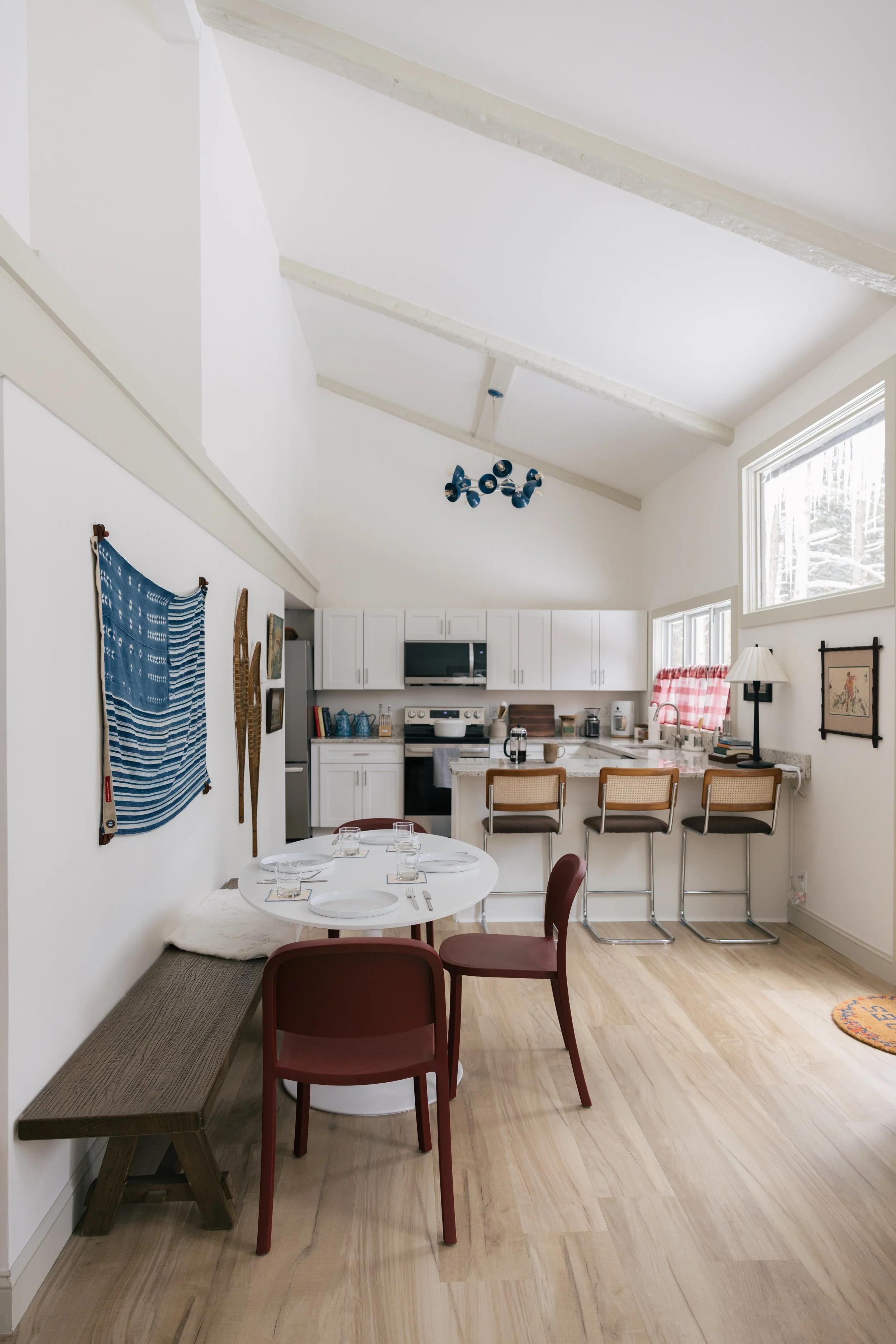 Open kitchen and dining area at Pine & Plaid in Quechee, Vermont with bar seating and table for four.