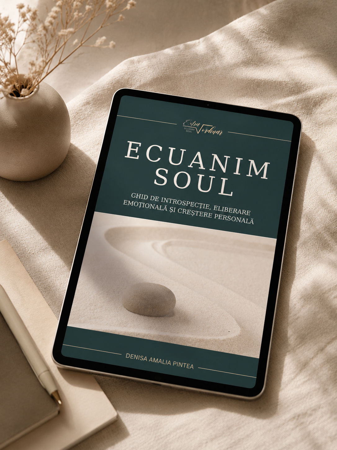 Tablet displaying a book cover titled 'Ecuanim Soul' by Denisa Amalia Pintea on a beige fabric surface, with a small white vase holding dried flowers, a closed notebook, and a pen nearby.