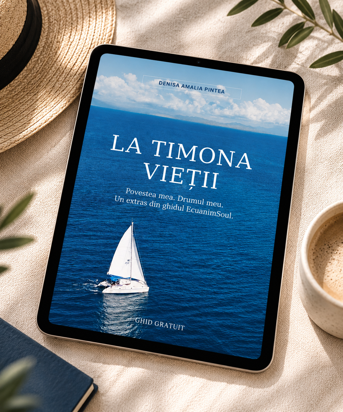 E-book cover on a tablet titled "La Timona Vietii" by Denisa Amalia Pintea, depicting a sailboat on the water with clouds in the sky, on a beige surface with a coffee cup, straw hat, and plants around.