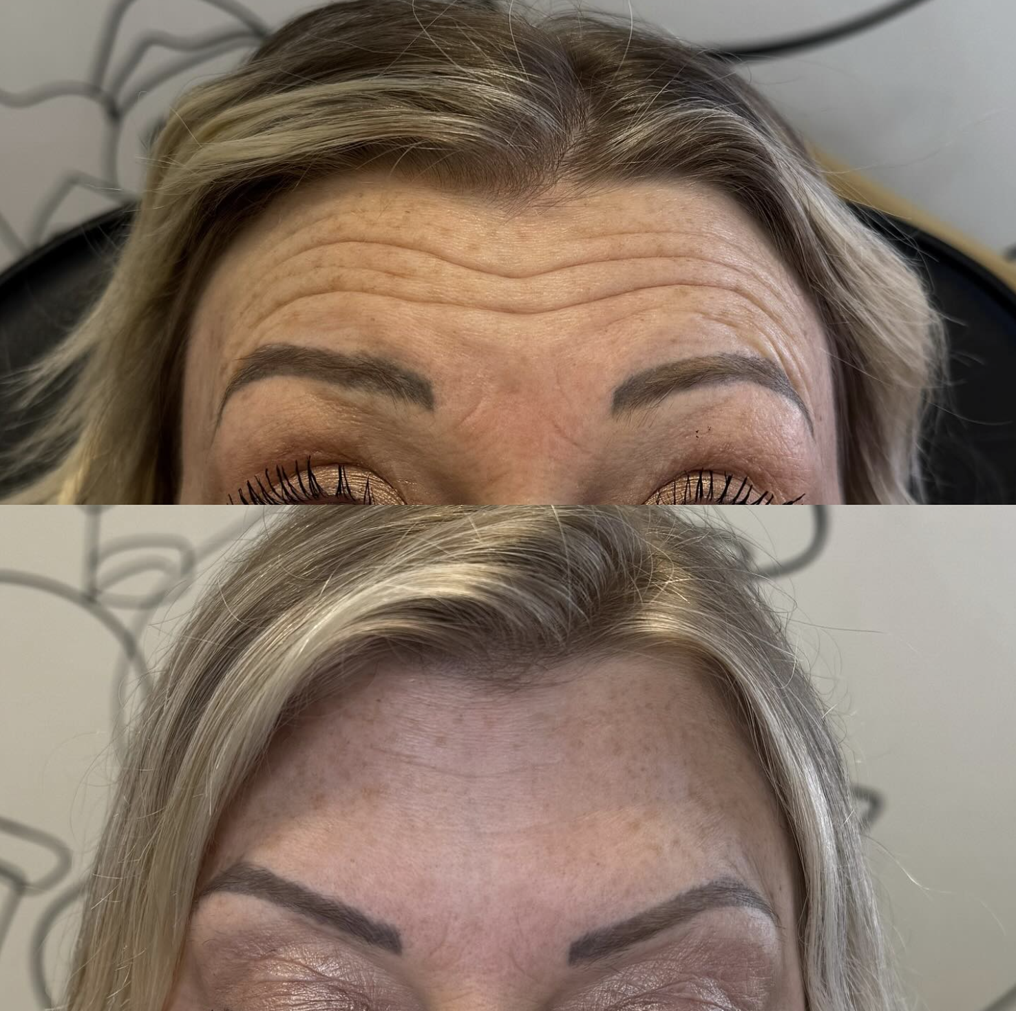 A minimalist ceramic vase with a speckled beige finish on a wooden surface, holding a few dried plant stems with small round seed heads, with indirect sunlight casting a shadow on the wall.