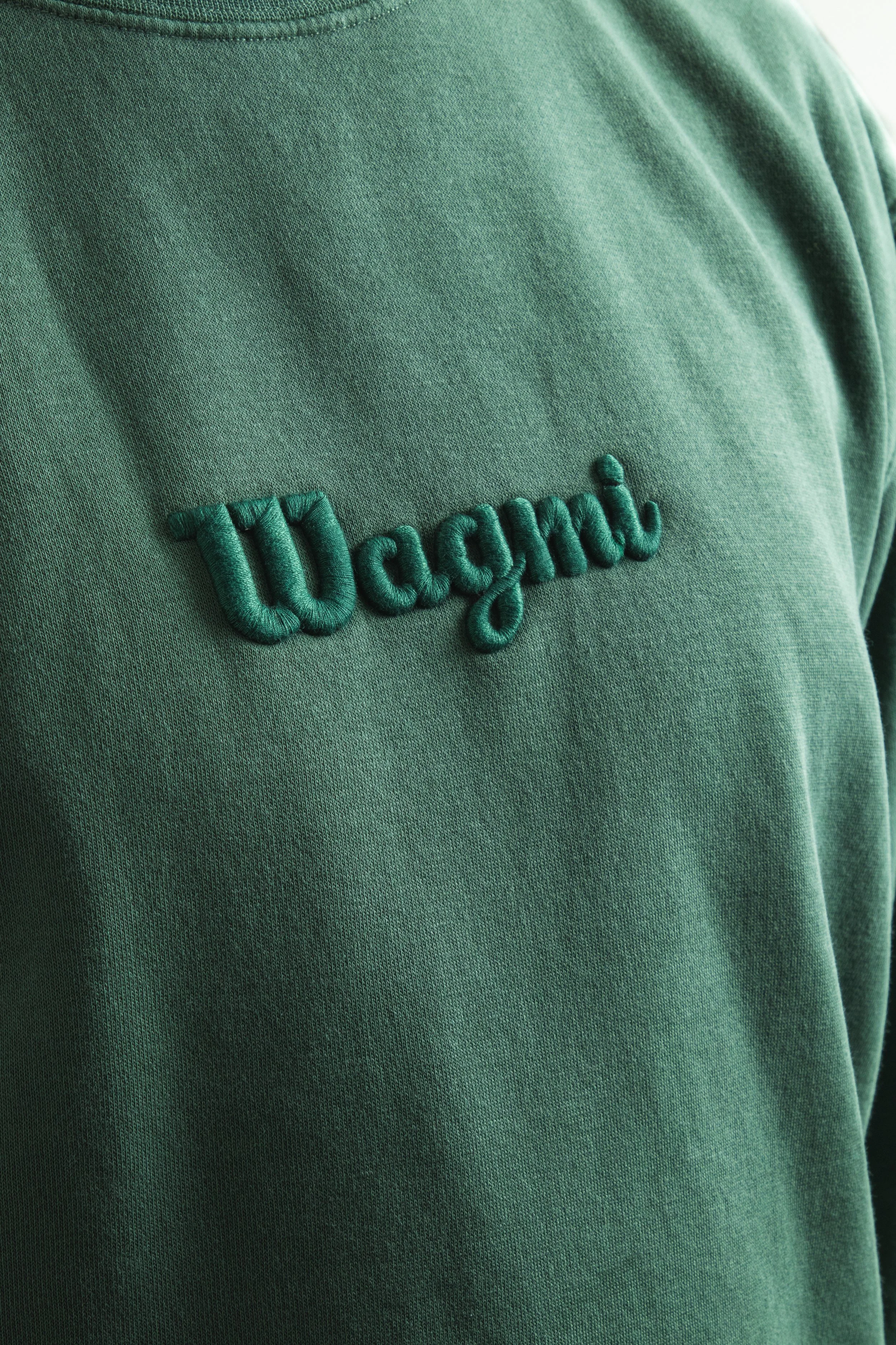 Close-up of a green sweatshirt with the word 'workout' embroidered on it in green thread.