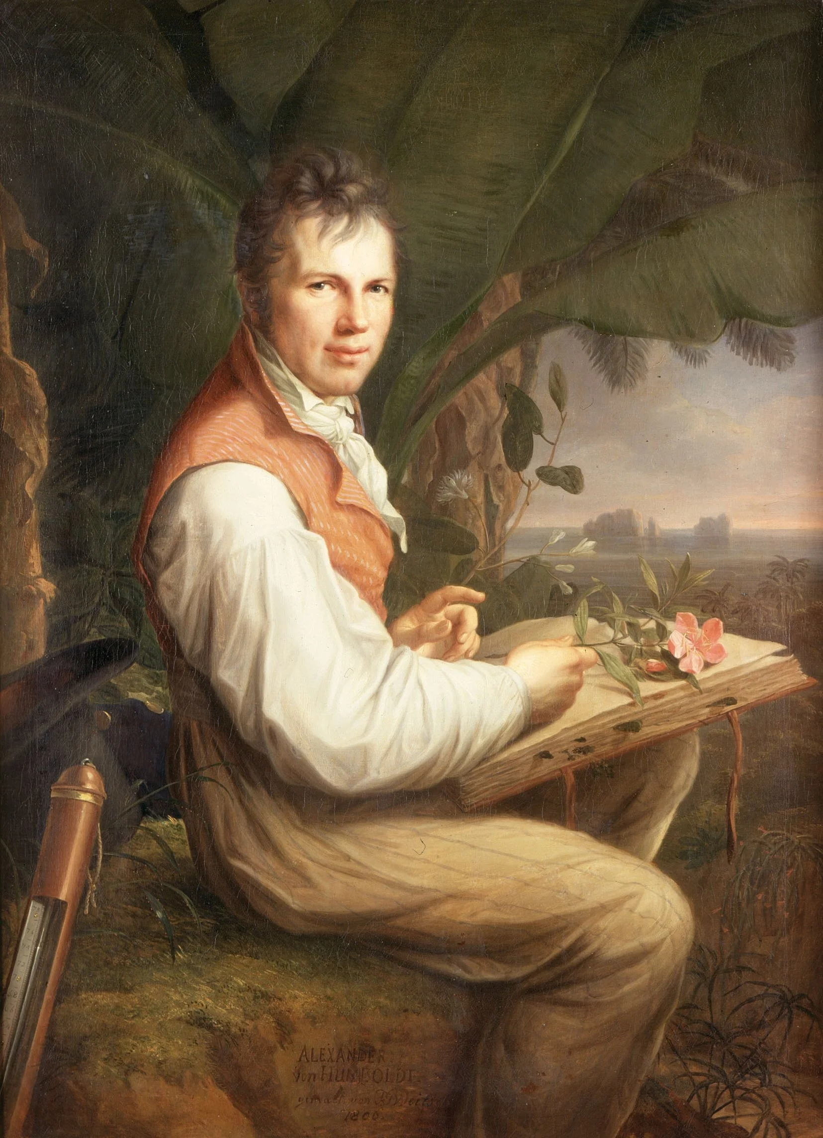 Alexander von Humboldt dressed in 18th-century clothing, sitting outdoors with large leaves behind him, holding a branch with pink flowers and a book. The background depicts a landscape with a river and trees.