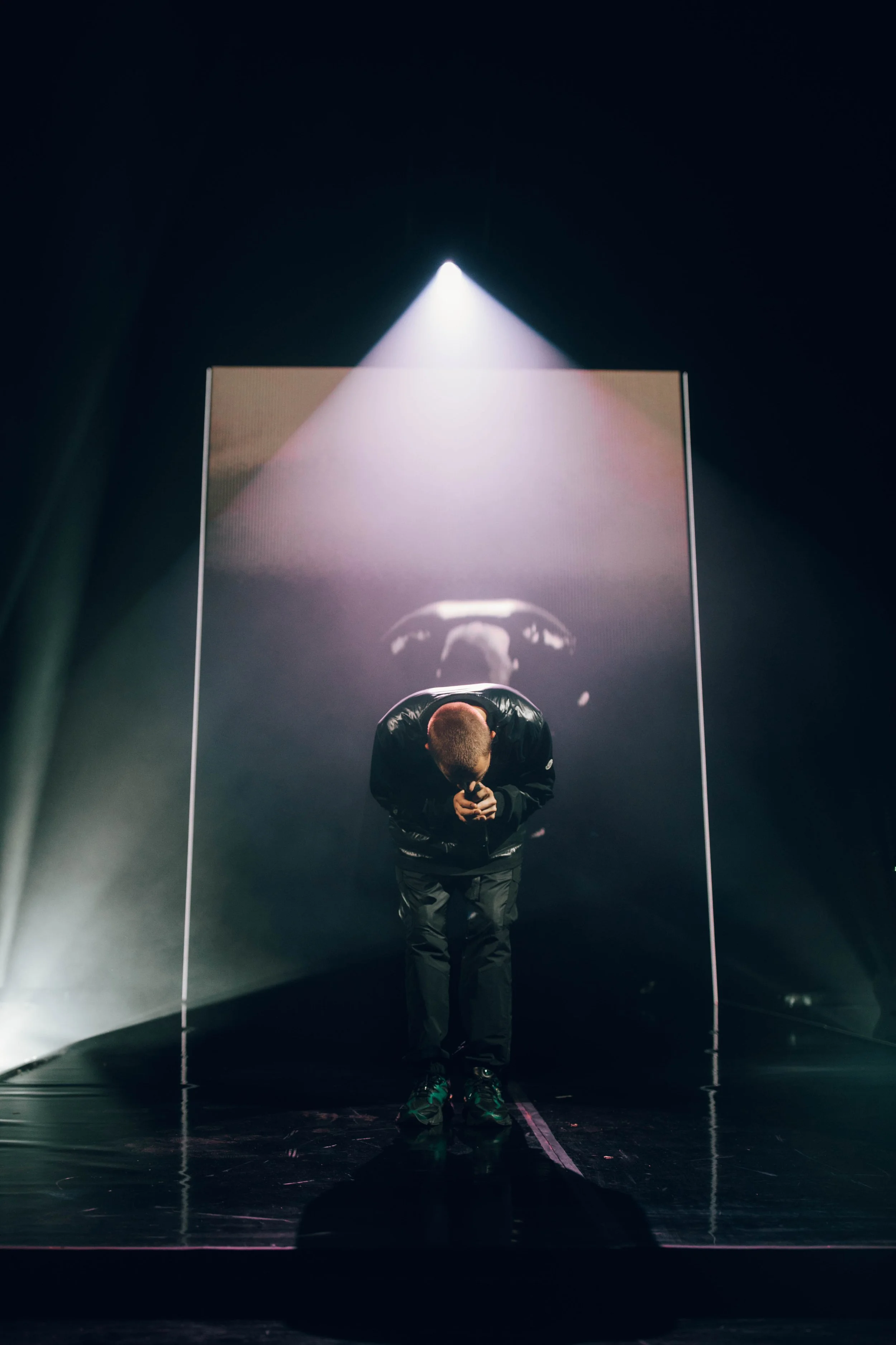 Dermot Kennedy on stage under a spotlight.