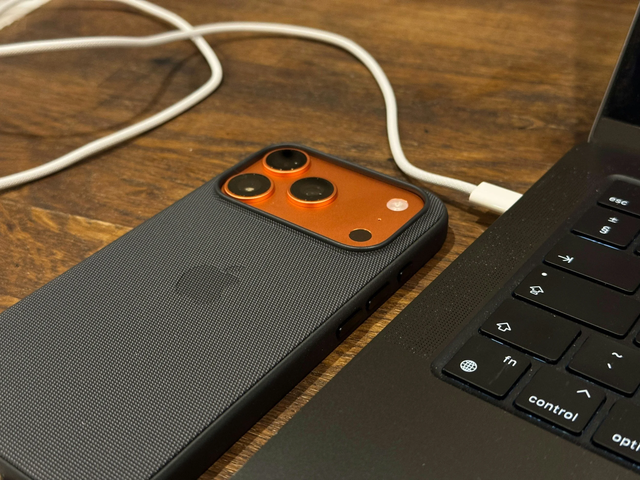 An Iphone 17 charging from a laptop