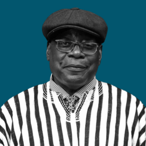 Close-up of a man wearing glasses, a beret, and a striped shirt against a solid background.