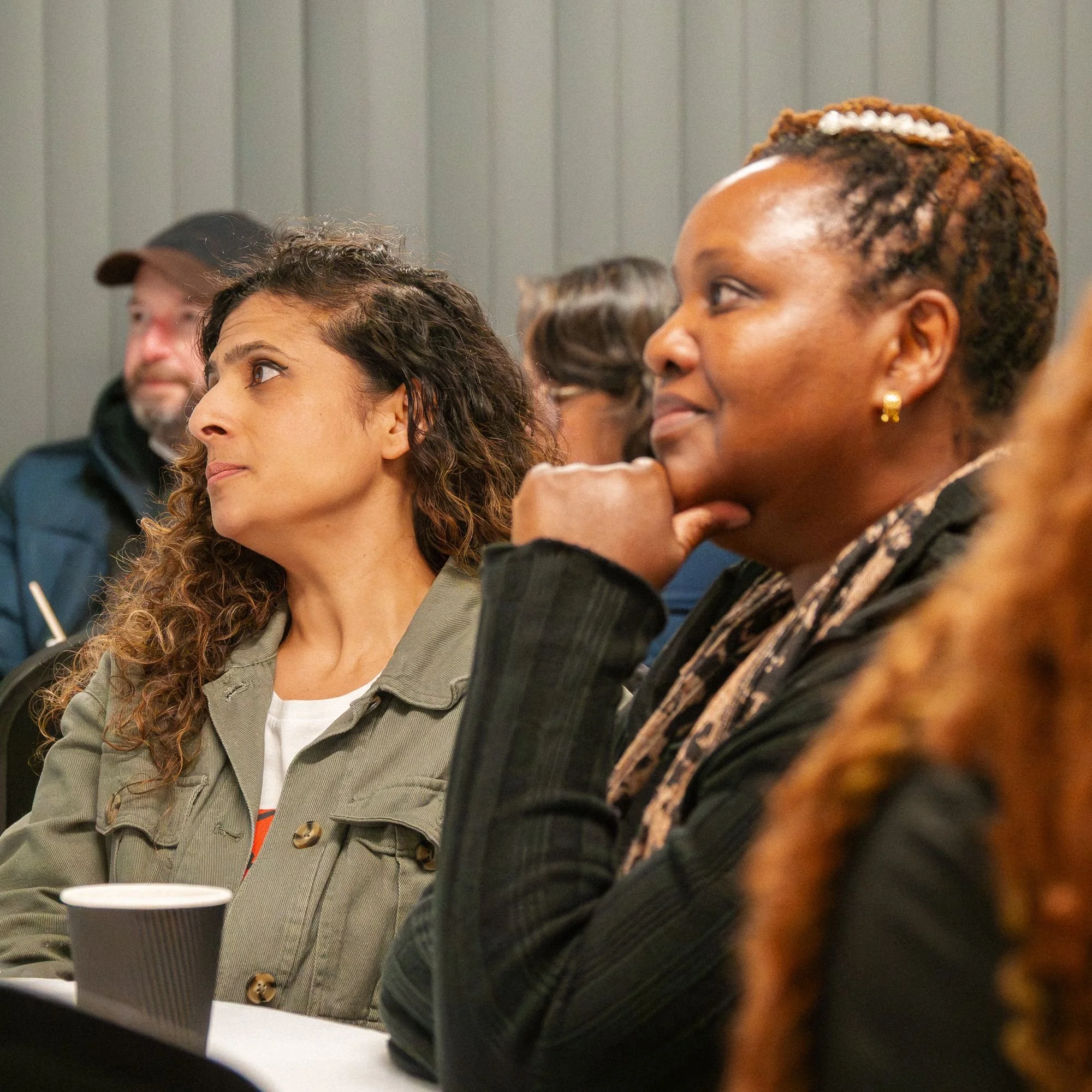 A group of people listening intently to a person speaking at an event