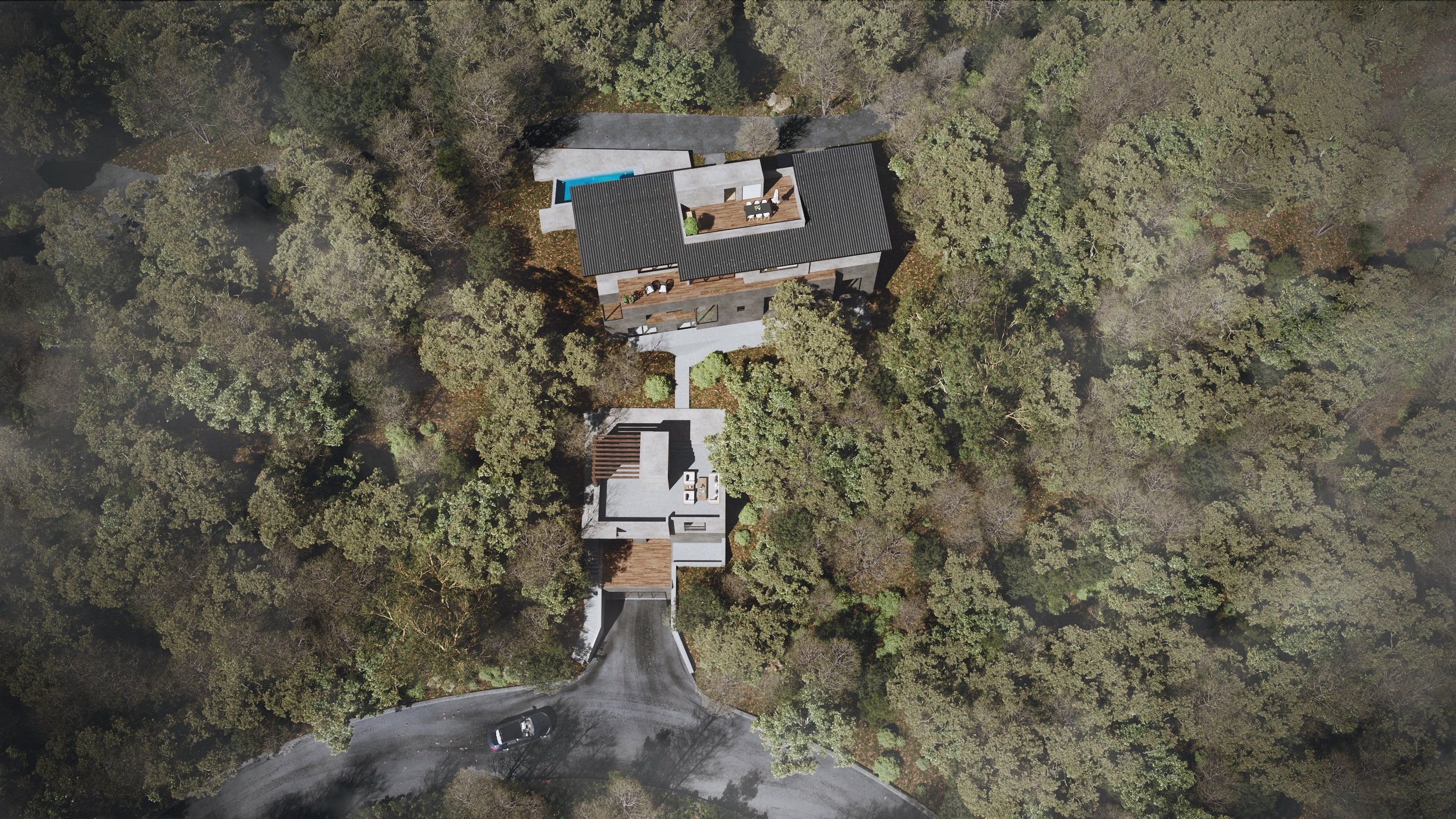 Aerial view of a house surrounded by trees with a driveway and a small parking area.