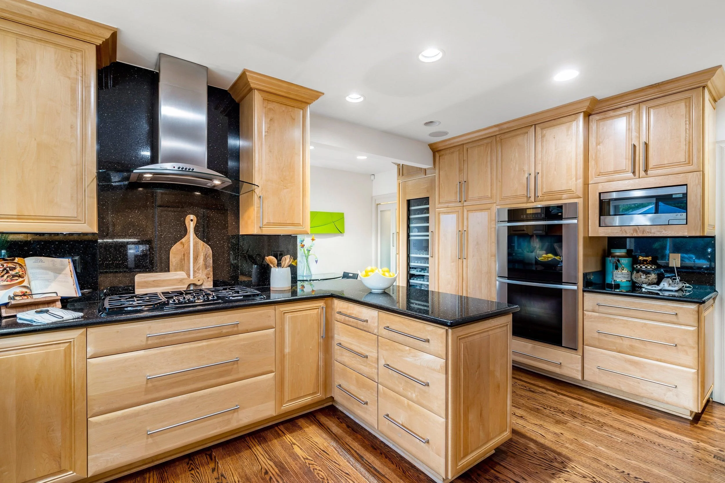 Kitchen with wooden cabinets, black granite countertops, stainless steel appliances, and a gas stove.