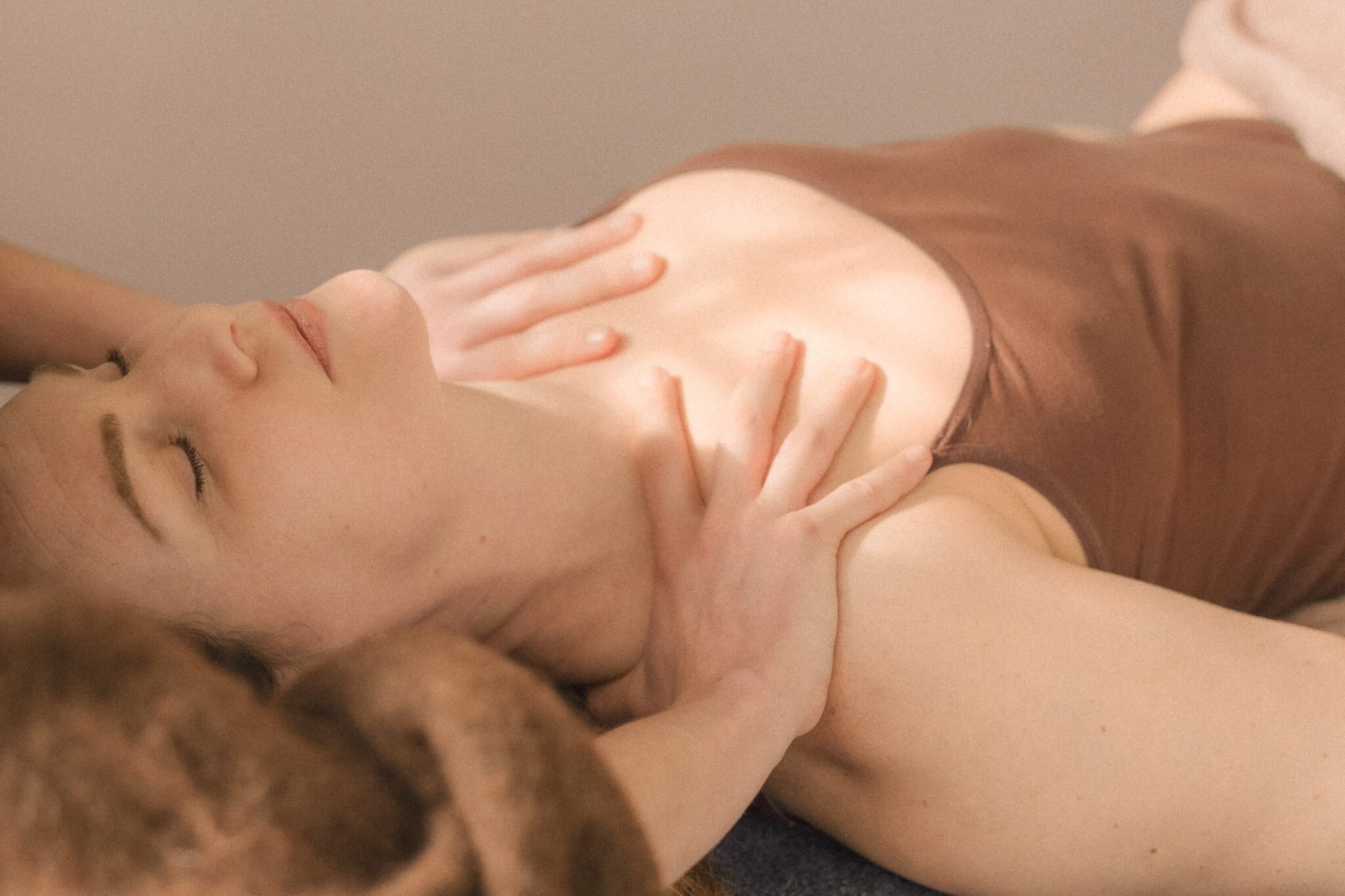 Een persoon ontvangt een massage op de rug door een tweede persoon bij daglicht.