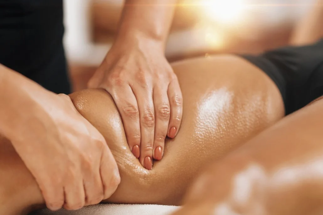 A person receiving a massage on their leg, with a focus on their calf muscle, by a massage therapist.
