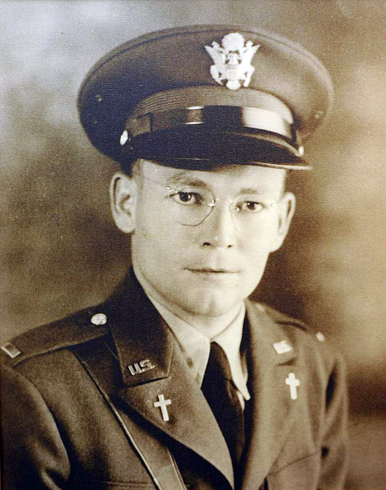 Black-and-white portrait of a U.S. Army chaplain in uniform with cap, glasses, and cross insignia on the collar