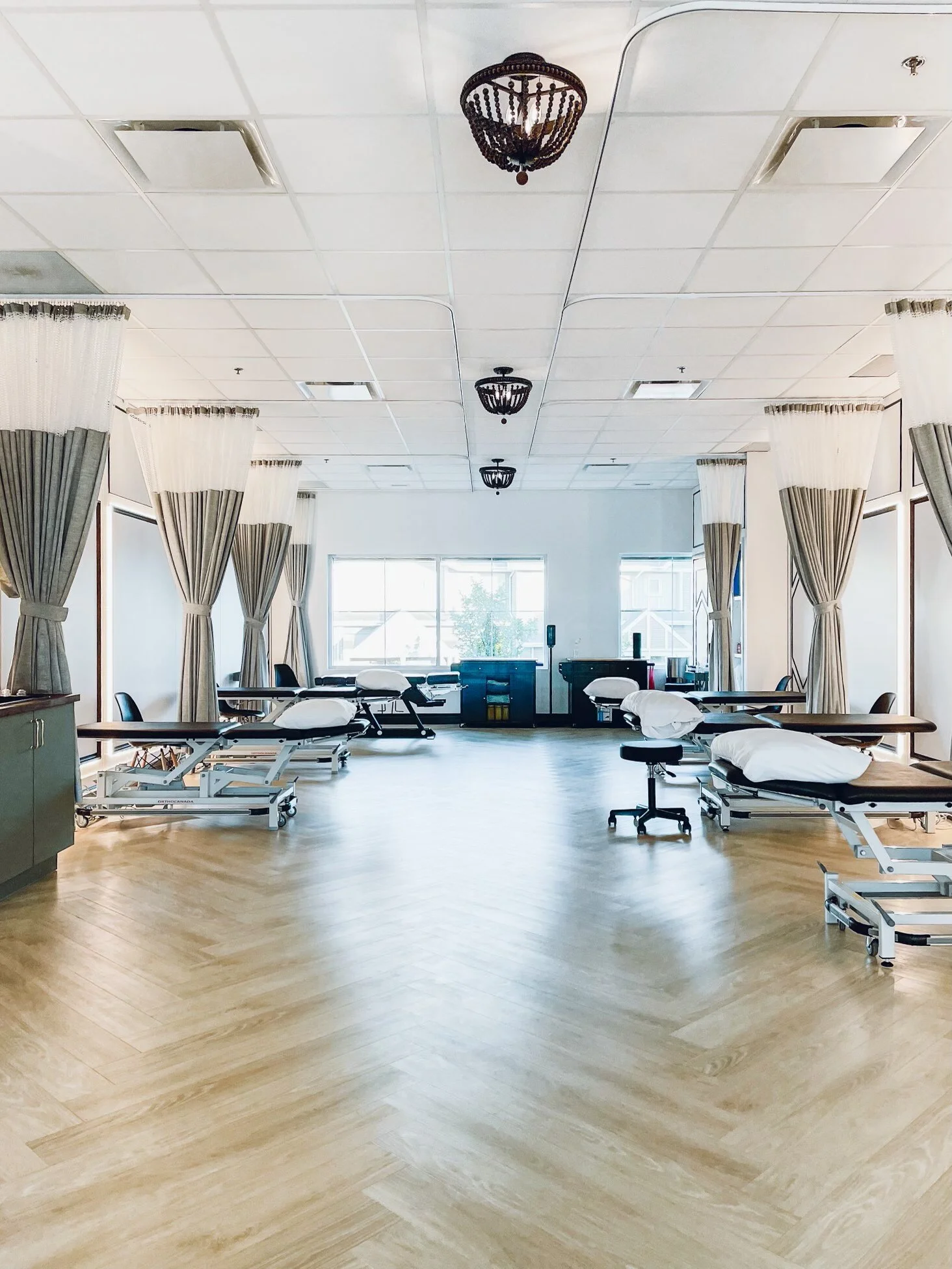 bright, spacious treatment room with beds for physiotherapy and chiropractic care