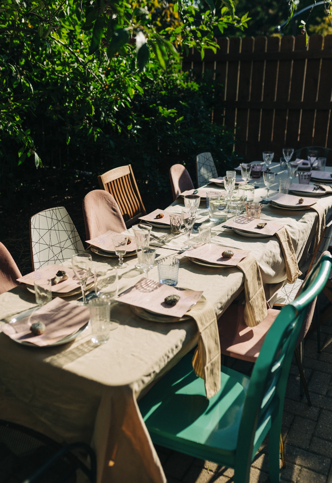 a beautiful table scape outdoors with a long table and empty chairs surrounding it