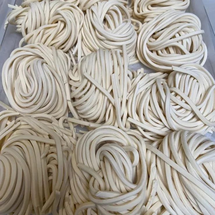 Raw spaghetti noodles arranged in small mounds on a surface.