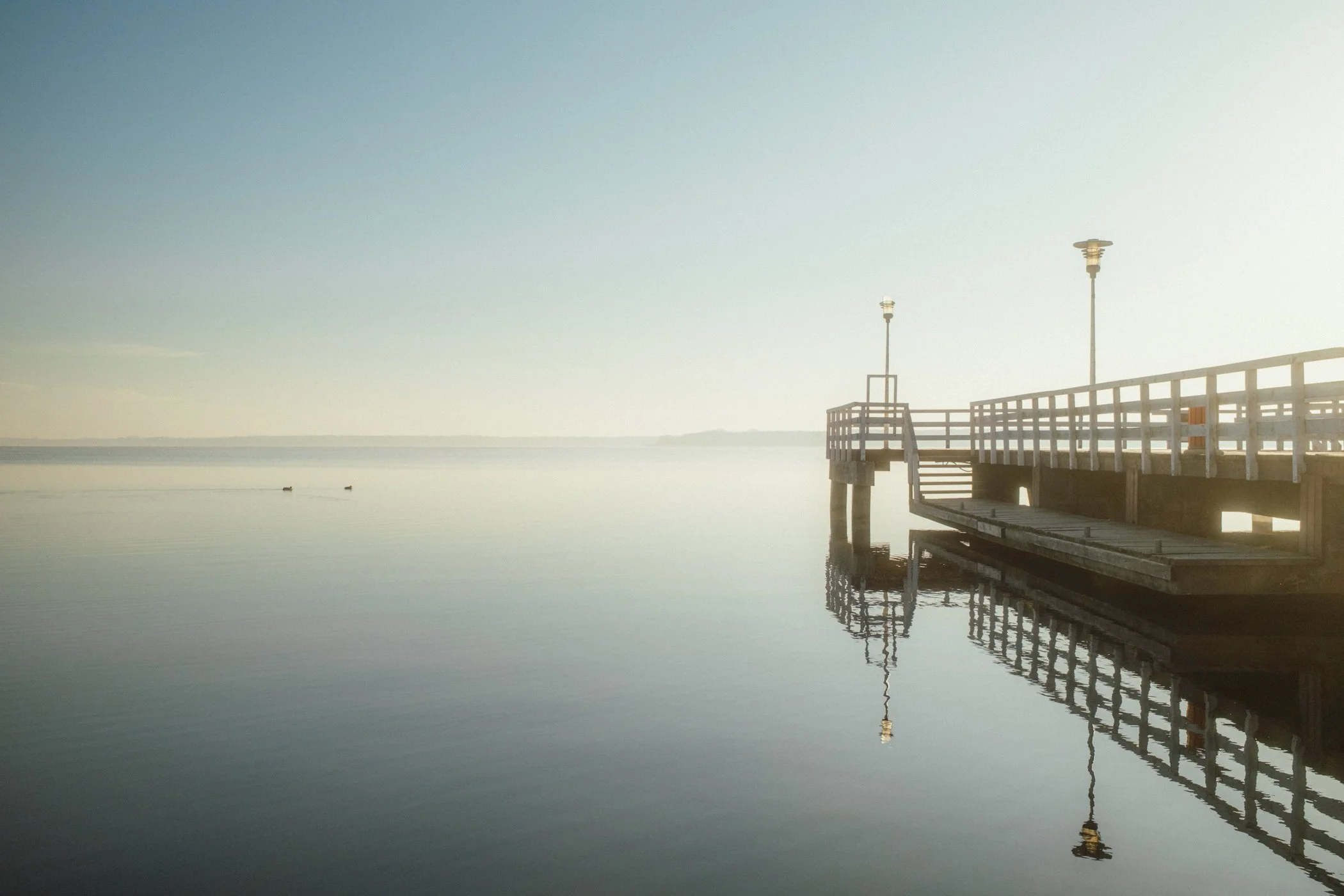 Pomost nad wodą w Nieporęcie widziany z boku w miękkim świetle