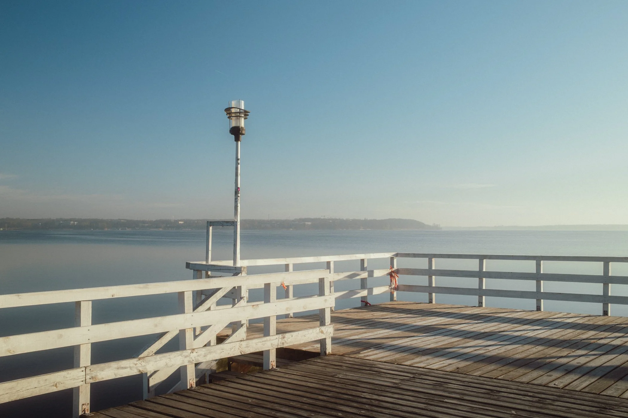 Drewniane molo nad Zalewem Zegrzyńskim w porannym świetle i lekkiej mgle