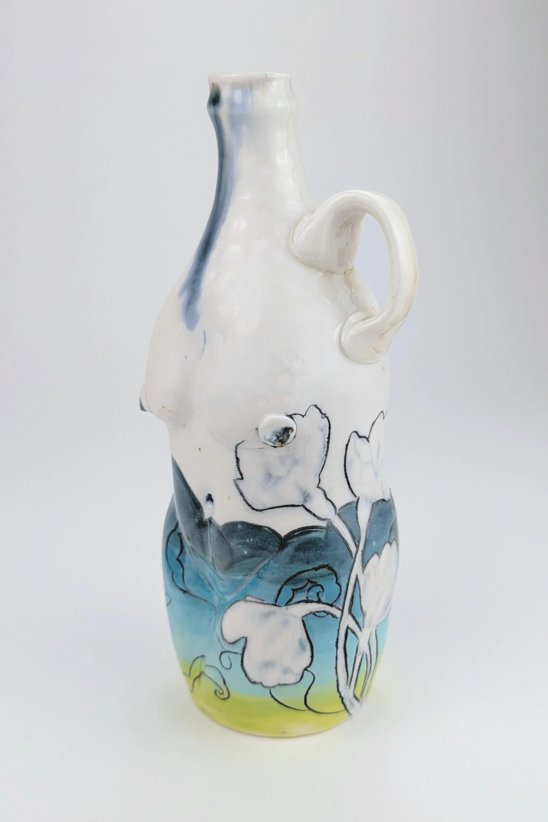 A ceramic vase with a floral design painted on it, featuring white flowers with black outlines against a background gradient of blue, green, and yellow.