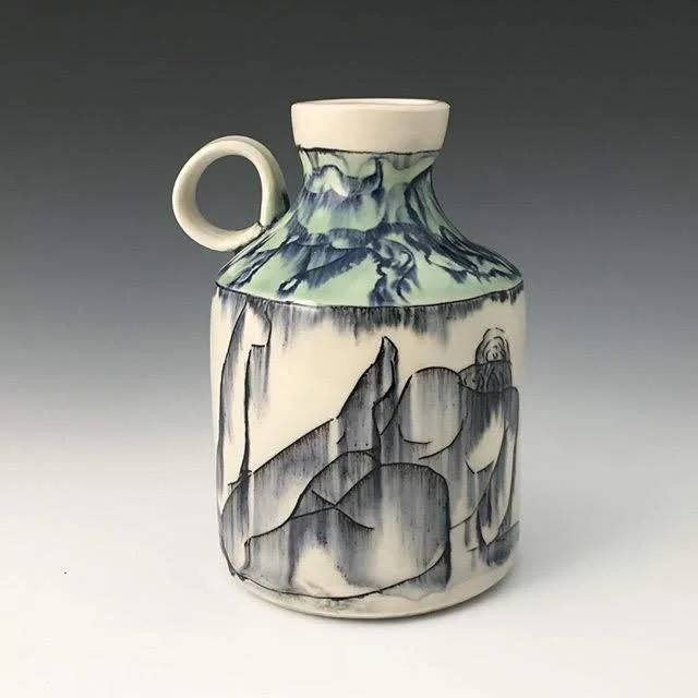 Ceramic jug with nude figurative line drawing and floral design in shades of gray, white, and blue.