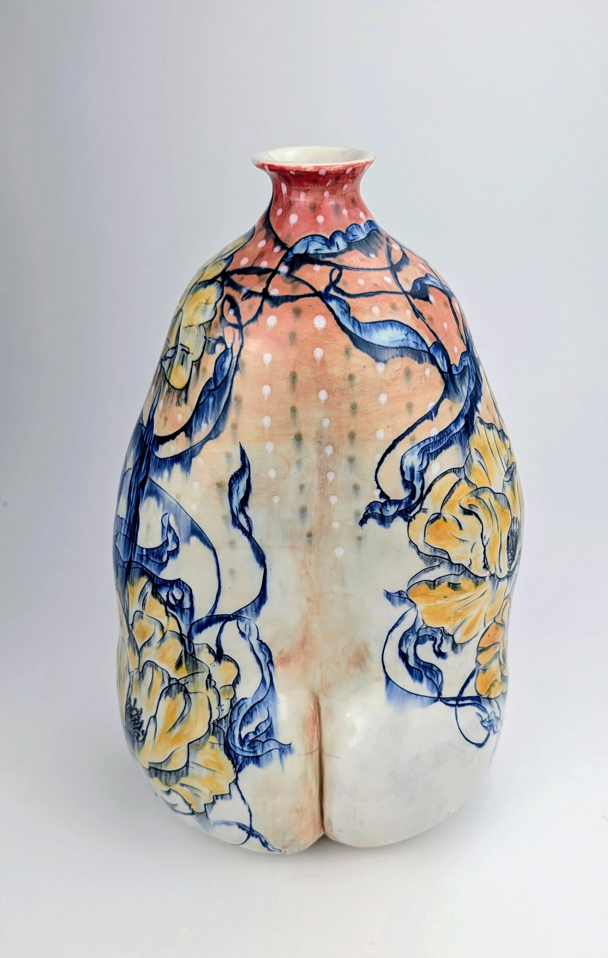 Decorative ceramic vase with floral and vine patterns in blue, yellow, and peach colors.