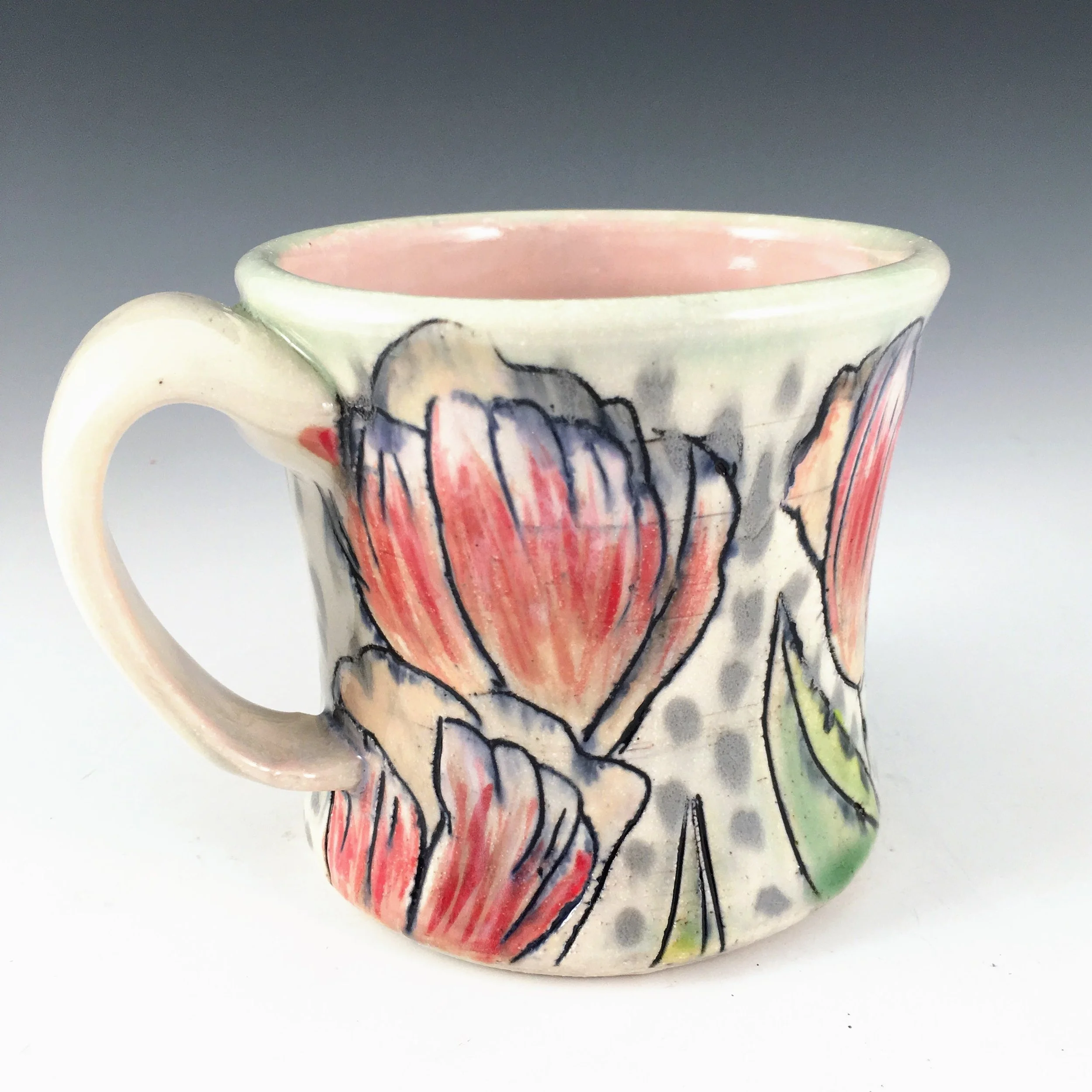 Ceramic mug with Tulip underglaze painting with black Mishima outlines and glaze pattern.