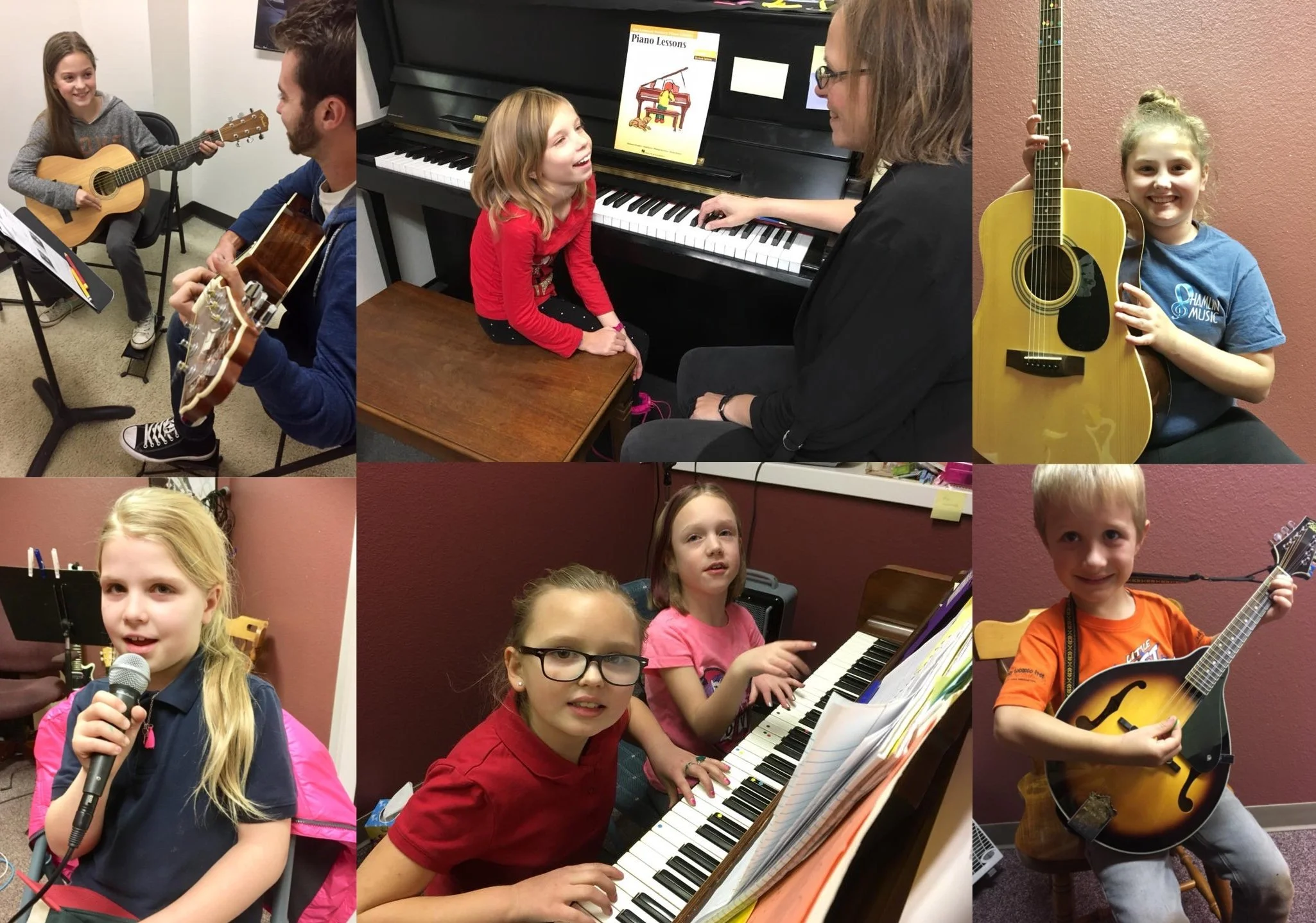 Children participating in a music class or band, playing and singing with guitars, pianos, and microphones, in a classroom or rehearsal space.