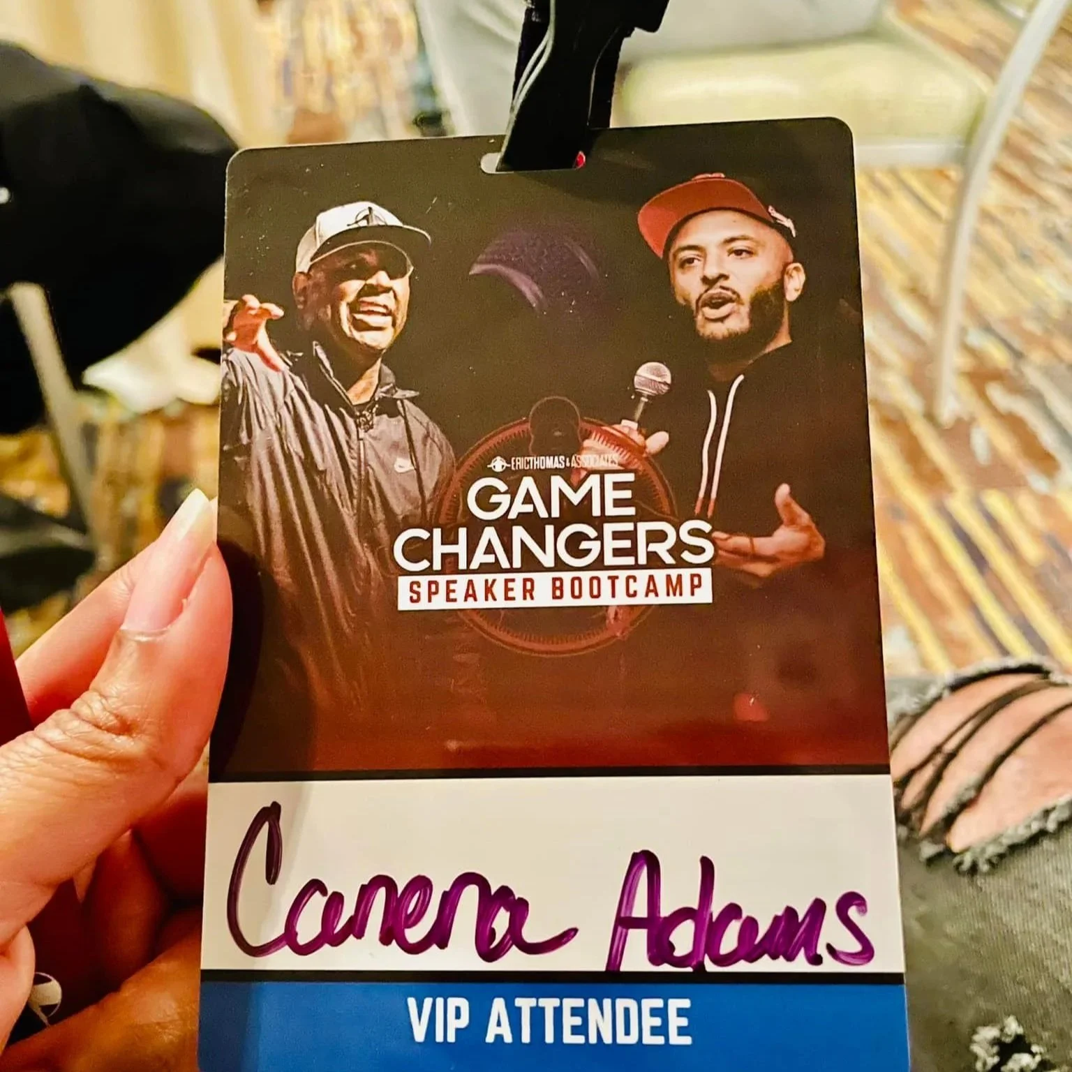 A VIP attendee badge for the 'Game Changers Speaker Bootcamp' conference featuring two men, one speaking into a microphone and the other smiling, set against a dark background with logos and event details.