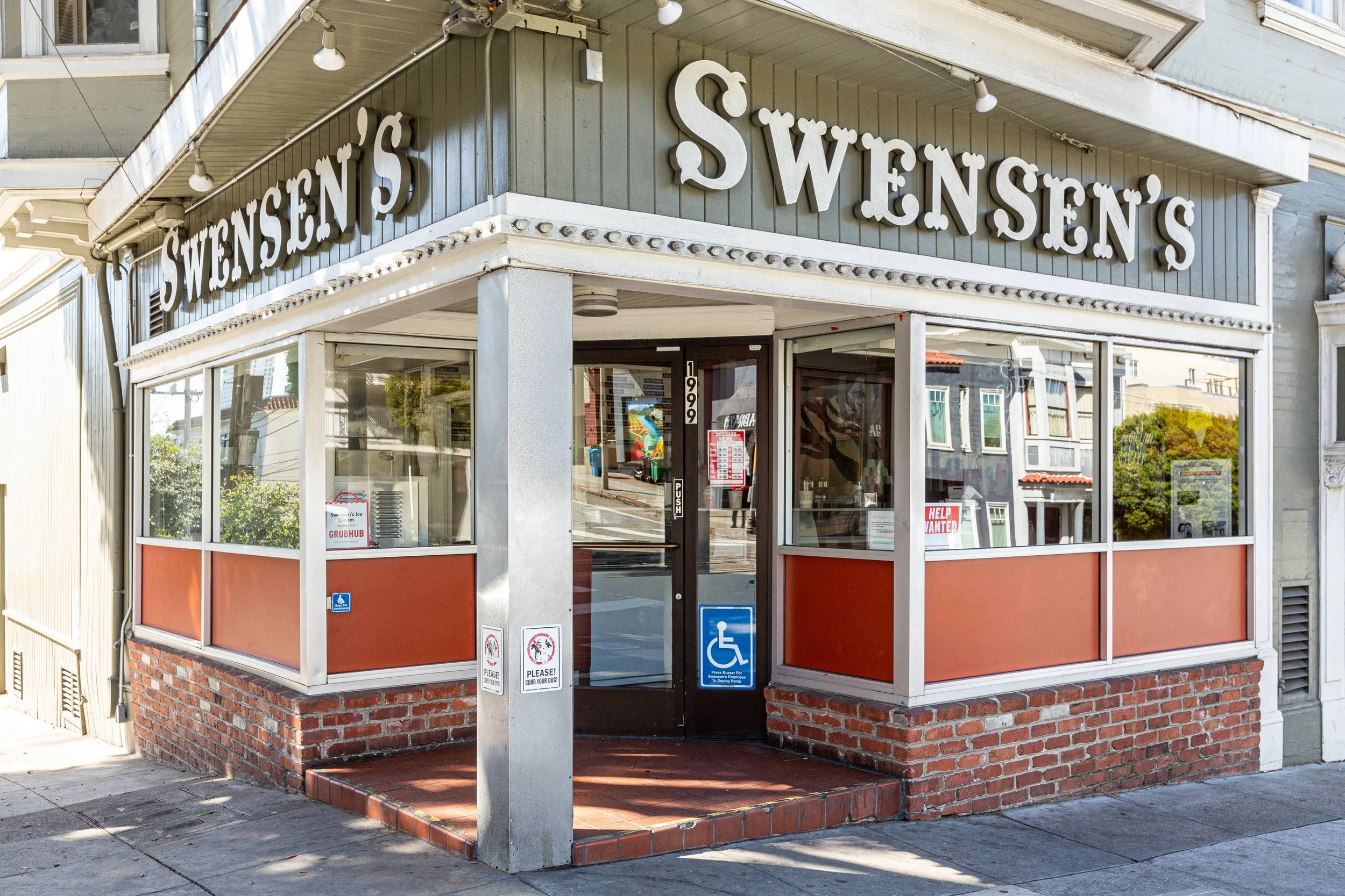 Exterior of Swensen's ice cream shop with large sign, glass windows, brick base, and wheelchair accessible entrance.