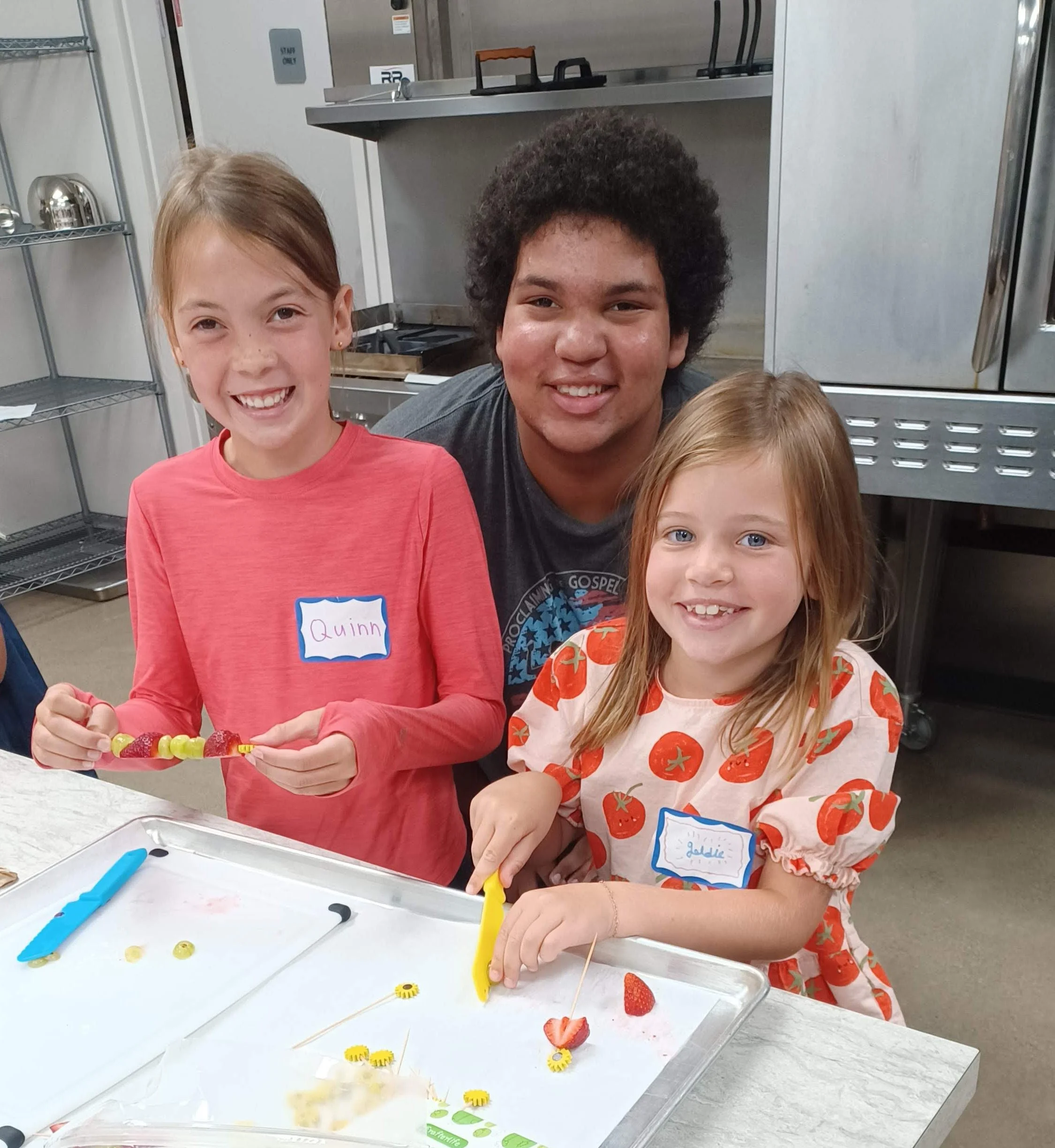 Two children and a volunteer working at a table