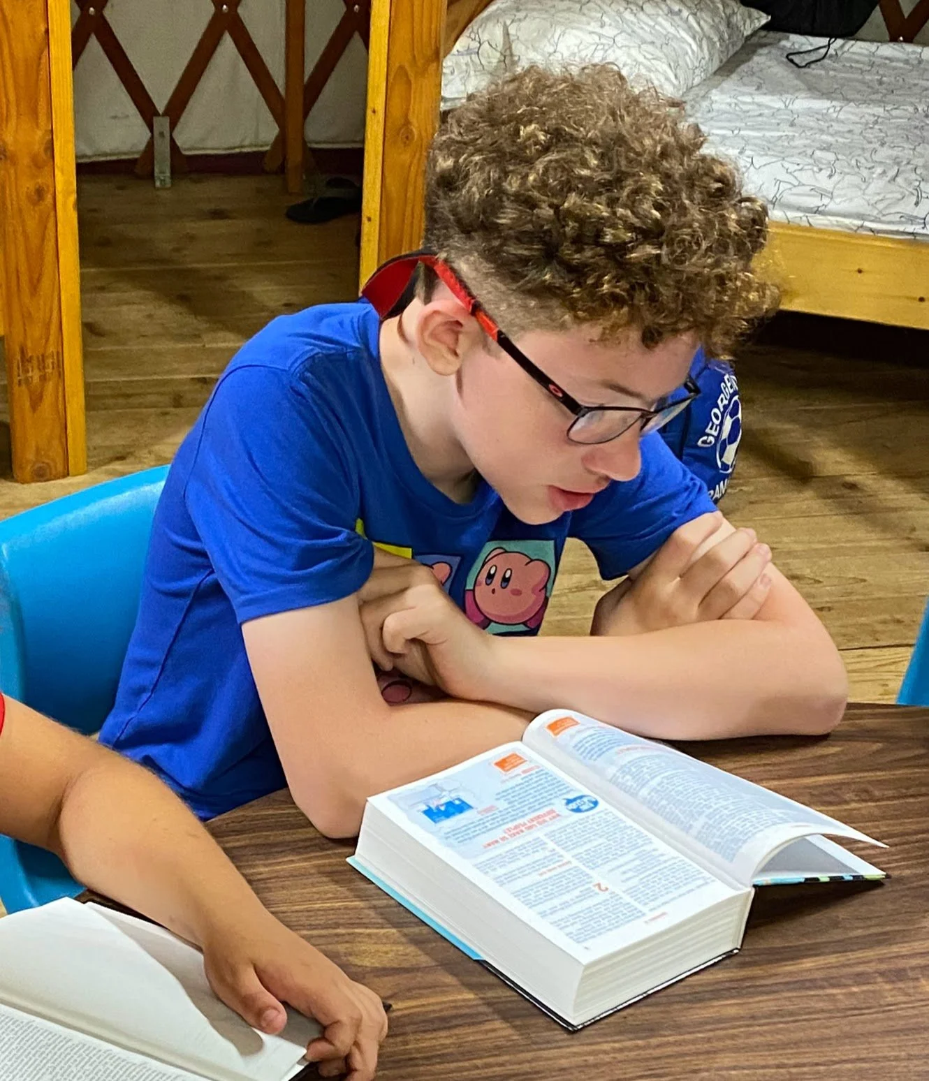 A boy reading his bible at a table