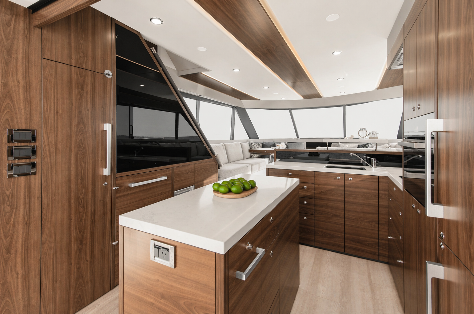 Modern yacht interior with wooden cabinetry, a small white kitchen island with a bowl of limes, and large windows with a city skyline view.