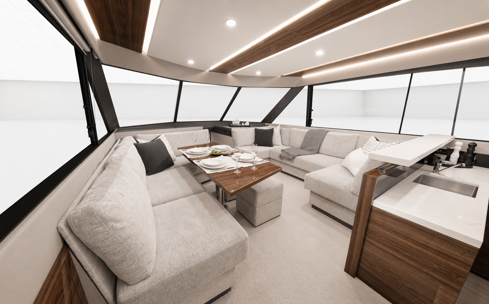 Interior of a modern yacht with a U-shaped light gray sofa, wooden table set with dishes and glasses, large windows, and a small kitchenette with sink and pepper grinders.