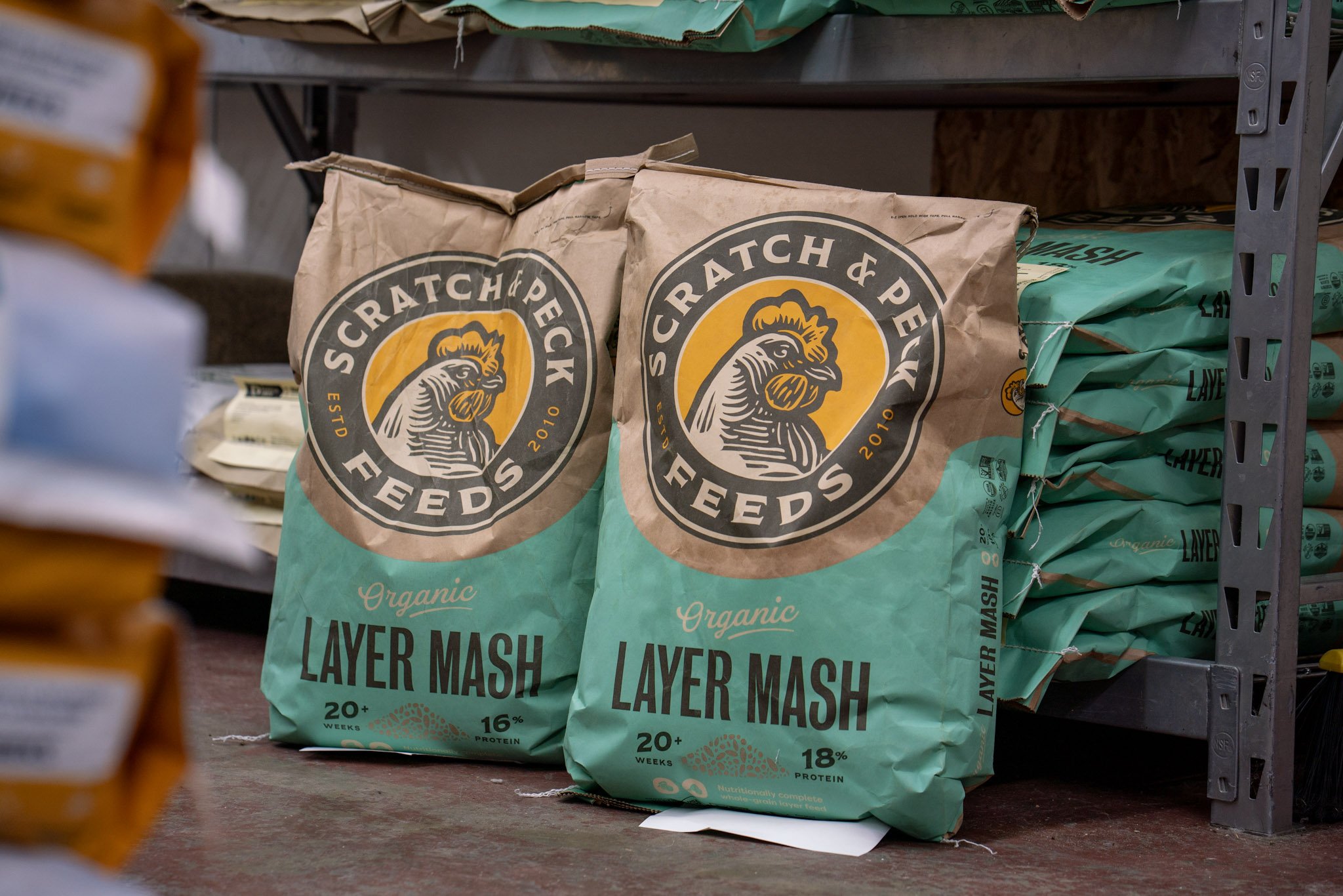 Bags of Organic Layer Mash chicken feed on store shelf.