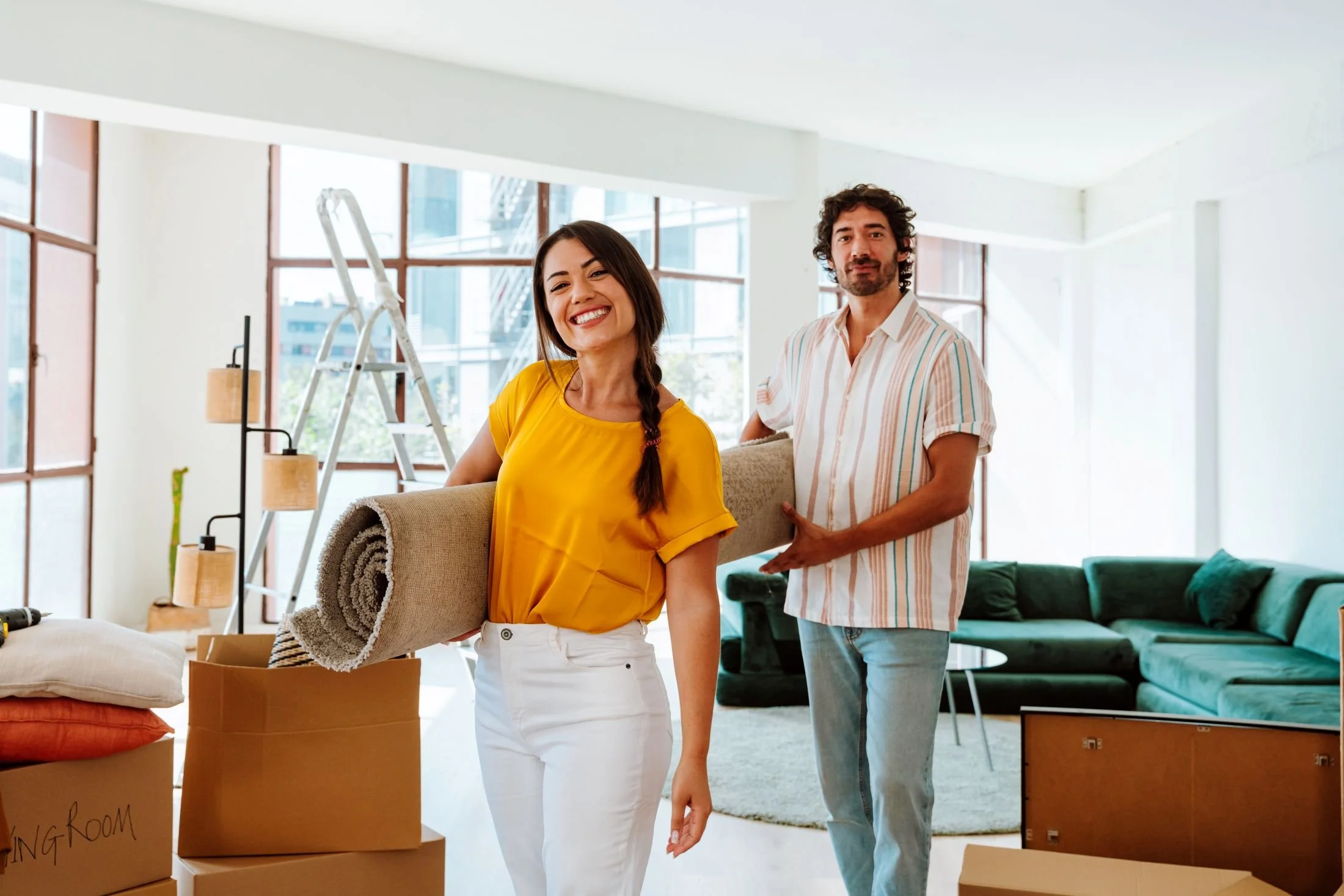 Couple moving a rug out of their home