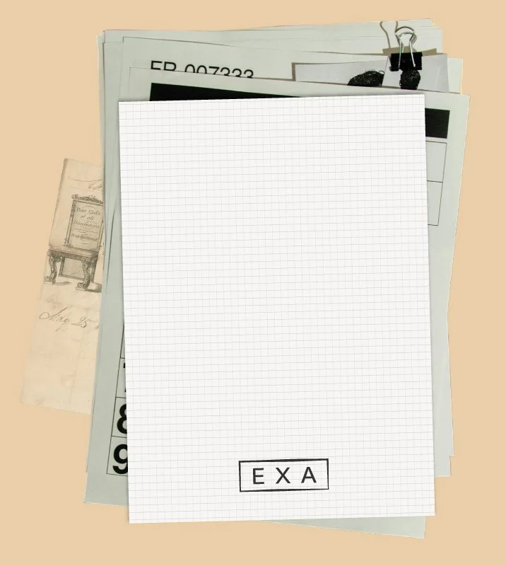 A stack of papers clipped together, with the top sheet being a piece of graph paper that has the letters "EXA" on it in black outlined letters.