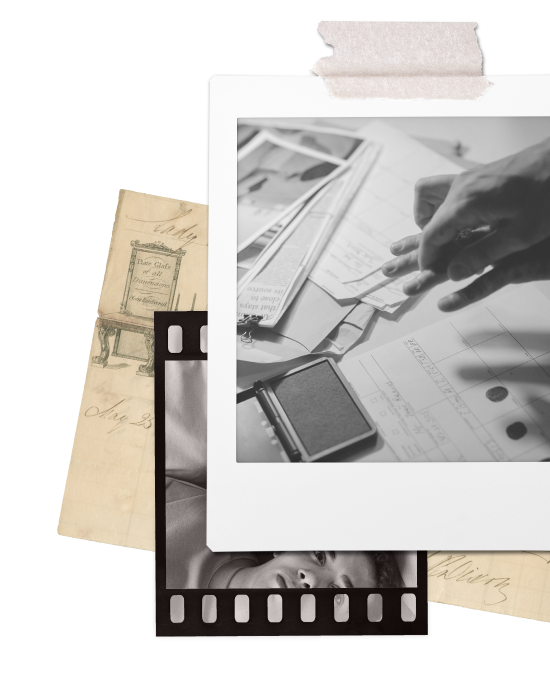 Black and white photograph of a person's hand handling receipts and papers on a desk, with some vintage tickets and negative film strip nearby.