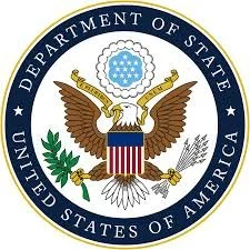 Emblem of the United States Department of State featuring a bald eagle holding an olive branch and arrows, with a shield on its chest, surrounded by a blue circle with the text 'Department of State' and 'United States of America'.