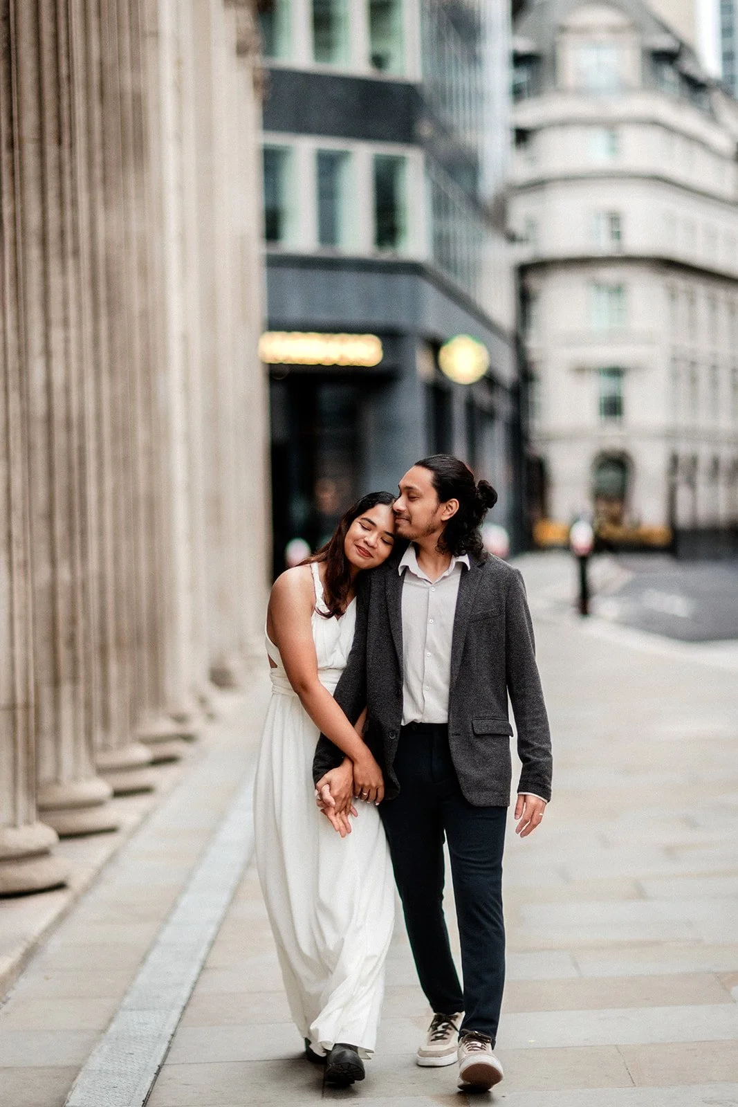A bride and groom walking down the path with her head resting on his shoulders taken by wedding photographer Darius N Fernandes in the Netherlands 