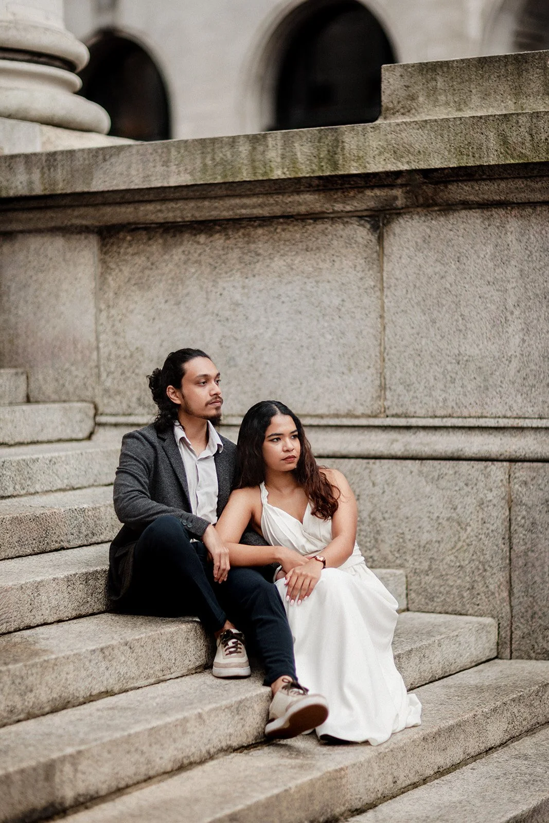 A wedding couple sitting on the steps of an old structure in Groningen taken by wedding photographer Darius N Fernandes