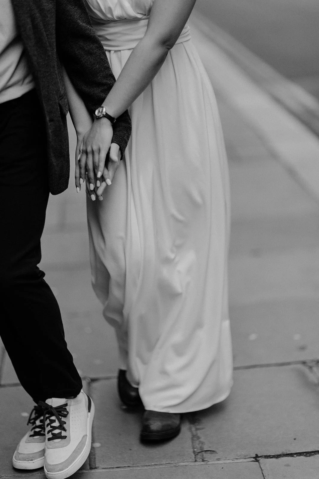 A photograph of a couple walking and having fun while clasping each others hands taken by wedding photographer Darius N Fernandes