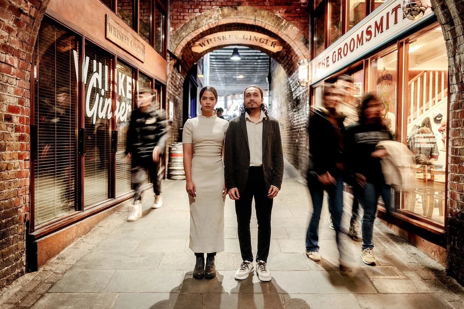 An artistic photograph of a couple standing still while the crowds while the people rush about around them in London taken by Darius
