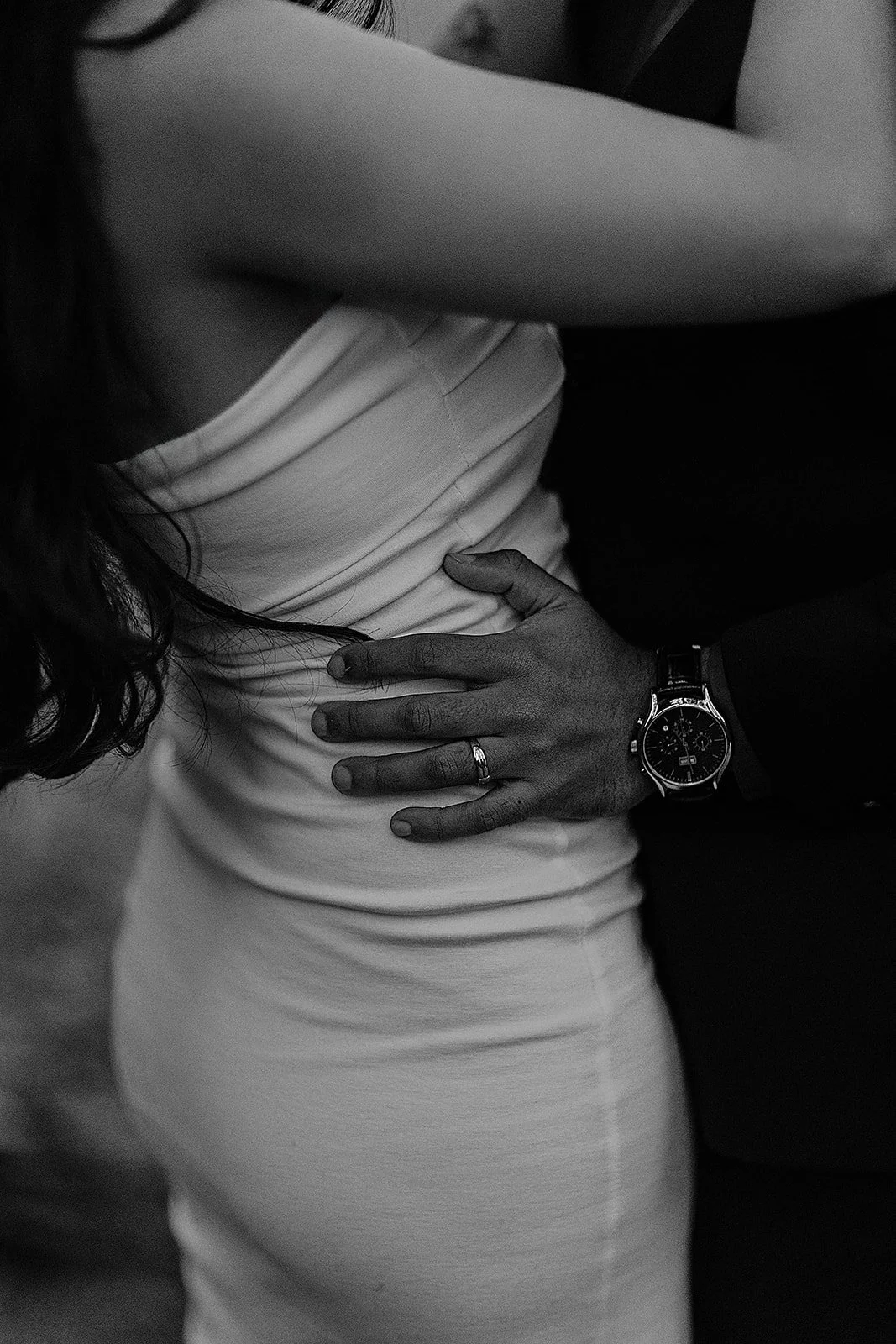 A photograph of the groom holding the brides waist as they share a kiss  taken by the photographer Darius N Fernandes