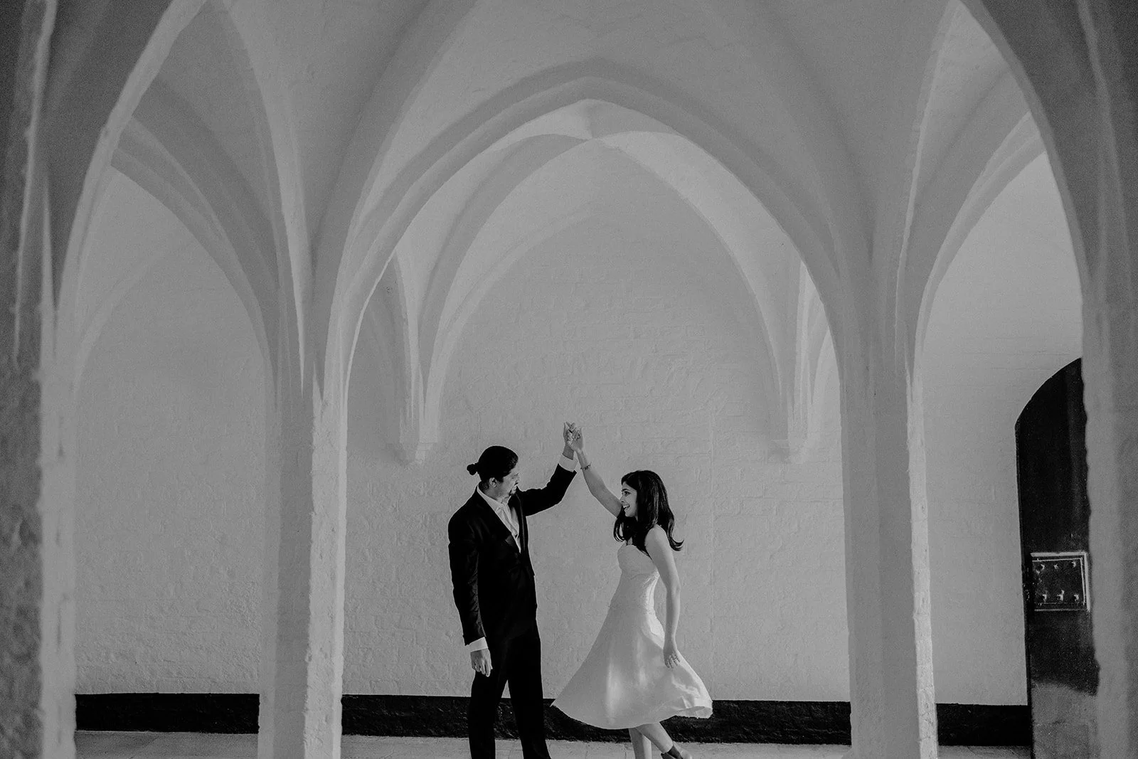A bride being twirled by the groom by an arched structure in groningen taken by Darius N Fernandes