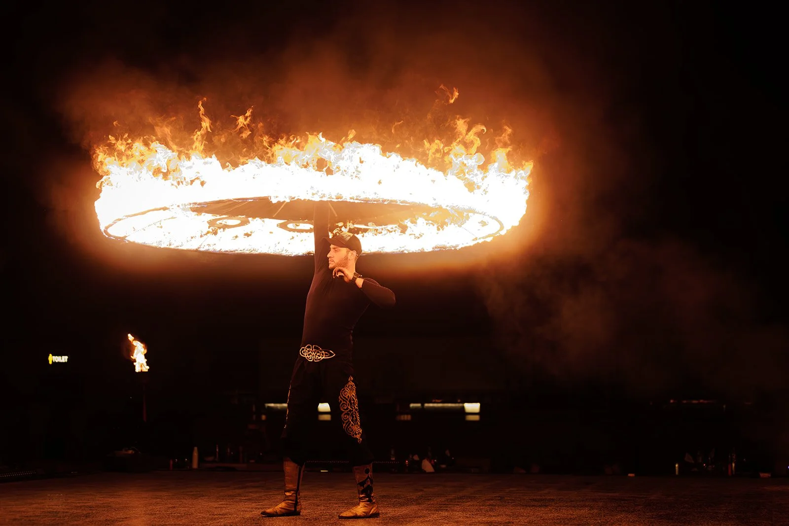 An event photograph of a fire dancer spinning fire in a circle in Dubai photographed by Darius N Fernandes in Dubai, from the Netherlands